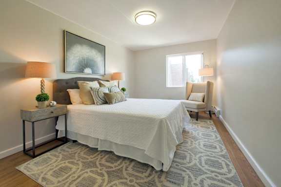 A bedroom with a large bed and a patterned rug.