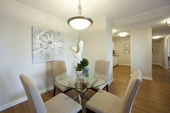 A dining room with a glass table and chairs.