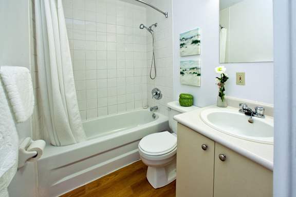 A white bathroom with a toilet, sink, and bathtub.