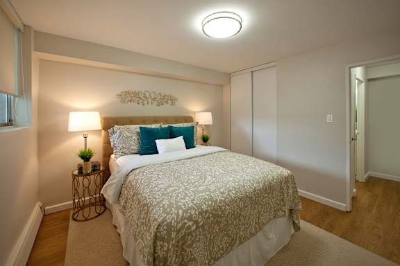 A bedroom with a bed, two lamps, and a wall decoration.