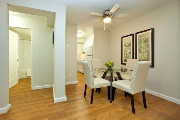 A dining room with a glass table and chairs.