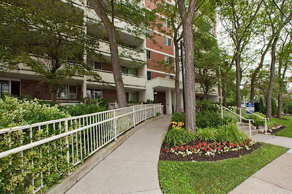 A building with a white fence and a flower bed in front.