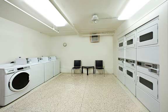 A laundry room with washers and dryers and a table and chairs.