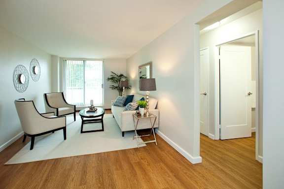 A living room with a white couch, a coffee table, and a lamp.