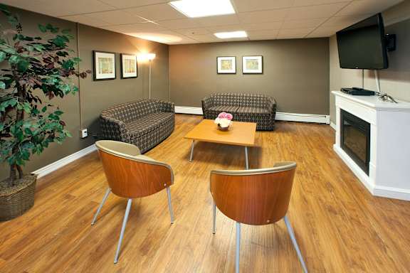 A living room with a brown chair and a brown couch.