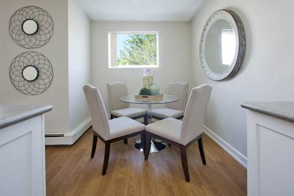 A dining room with a glass table and chairs.