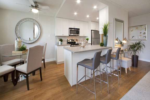 A modern kitchen with a bar area and chairs.