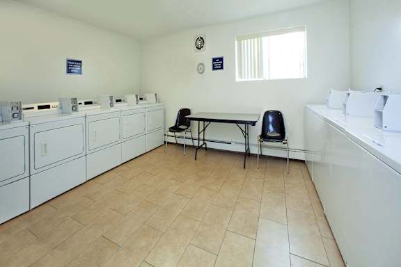 A room with a table and chairs and a white counter.