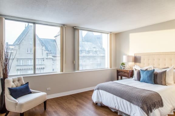a bedroom with a bed and three windows