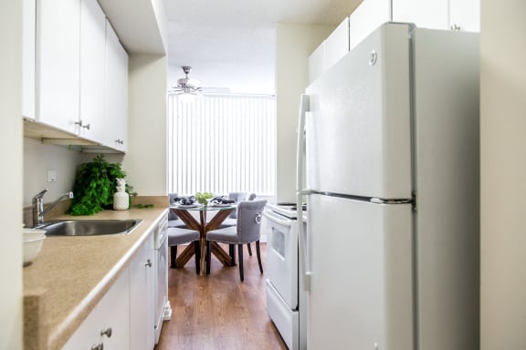 a kitchen with white appliances and a dining room with a table