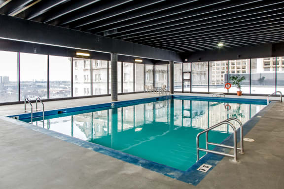 a swimming pool on the top floor of a building with a city view