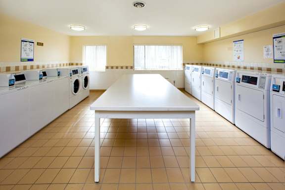 A laundry room with a table in the middle and washing machines on both sides.