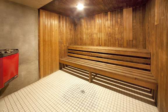 A wooden bench in a room with a tiled floor.