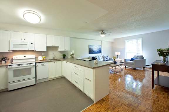 a kitchen and living room with white appliances and a counter top