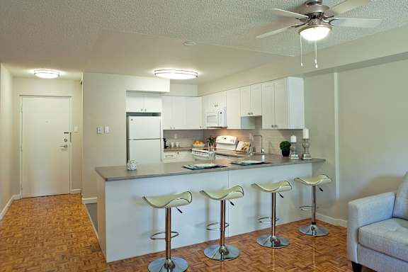 an open kitchen and living room with a bar and stools