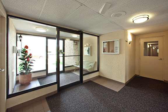 a lobby with a potted plant in the corner of a room