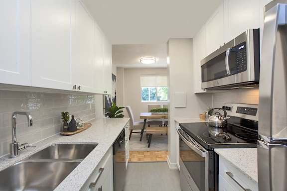 a modern kitchen with stainless steel appliances and white cabinets