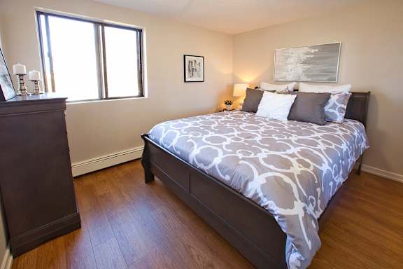 a bedroom with a bed and a dresser and a window