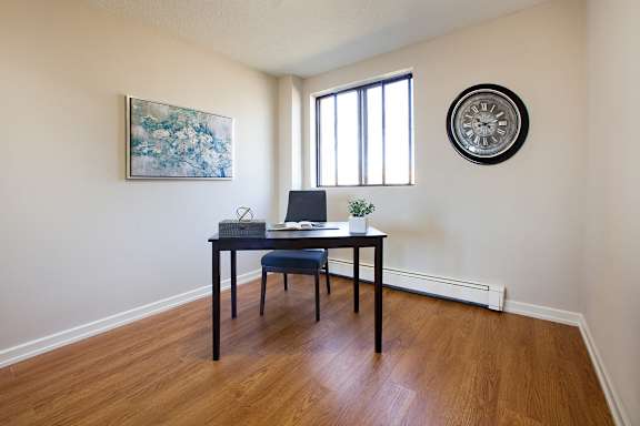a home office with a desk and a laptop on top of it