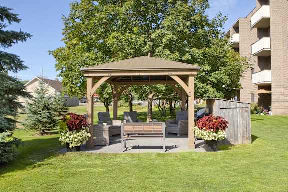 a wooden gazebo with a seating area and a swing