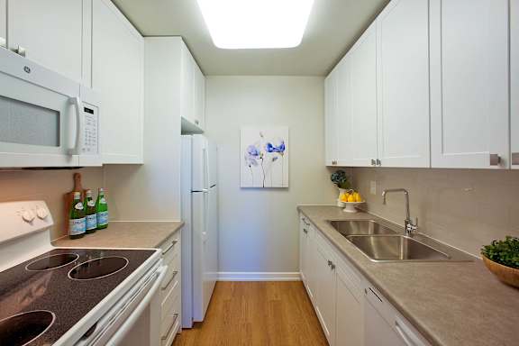a kitchen with white cabinets and stainless steel counter tops and a sink