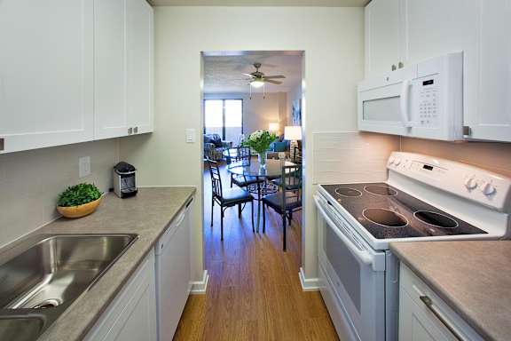 a kitchen with a stove and a sink and a dining room