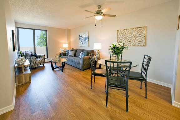 a living room and dining room with a table and chairs and a ceiling fan