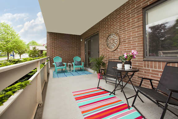 a balcony with a table and chairs and a brick wall