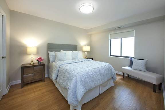 a bedroom with a bed and a chair and a window
