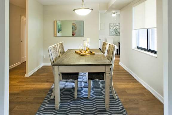 a dining room with a wooden table and chairs