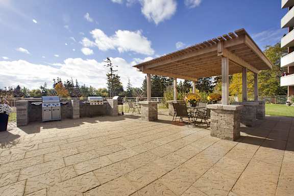 a patio with a grill and a pergola