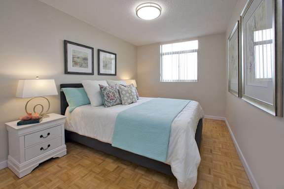 a bedroom with a bed with a blue blanket and pillows