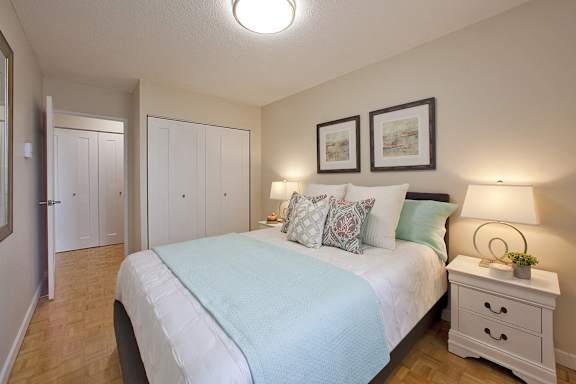 a bedroom with a large white bed and a white closet