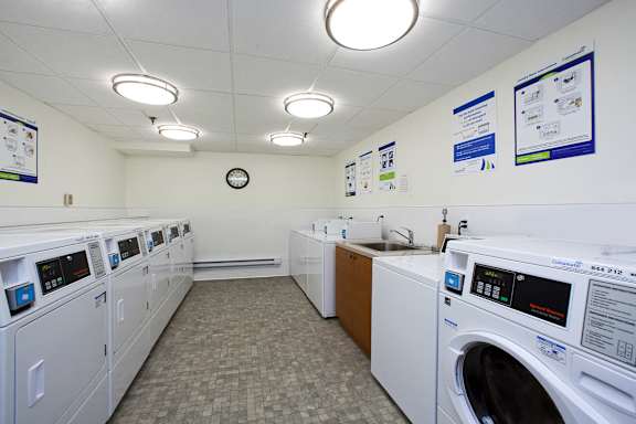 a laundry room with washers and dryers and a sink