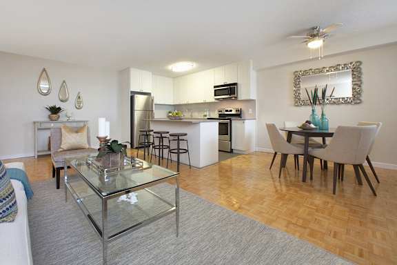 a living room and kitchen with a glass table and chairs