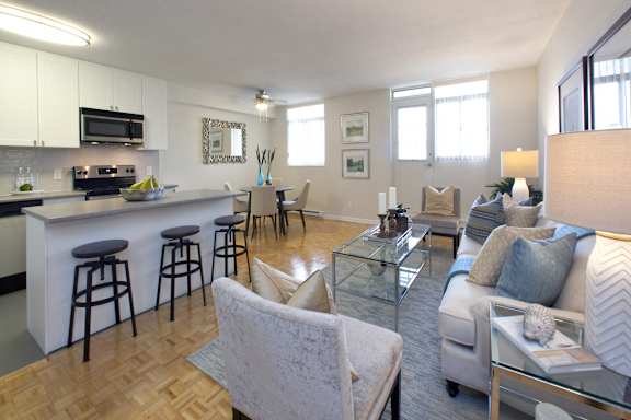 a living room with a couch and a kitchen with a bar