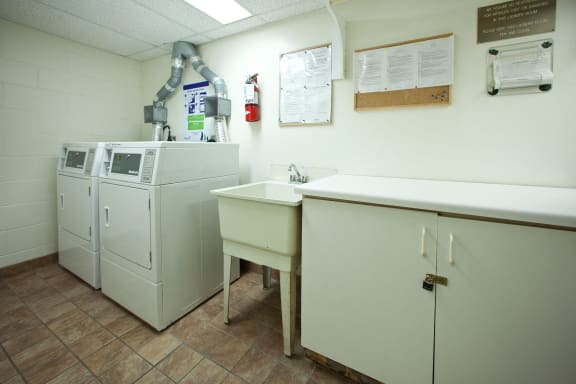 a laundry room with two washing machines and a sink