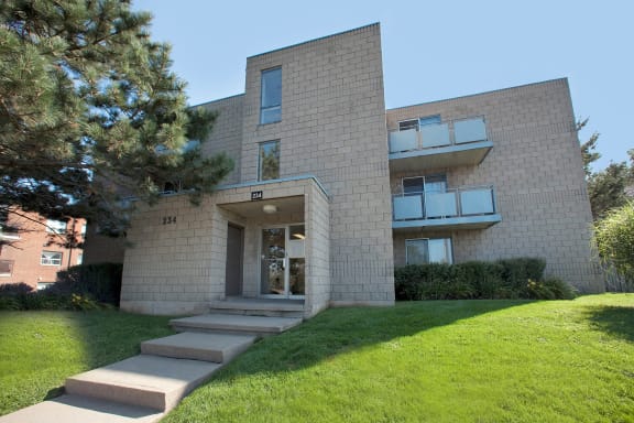 the front of a brick apartment building on a sunny day
