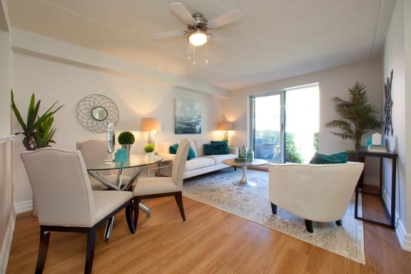 a living room with a ceiling fan and a table with chairs