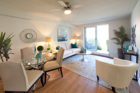 a living room and dining room with a glass table and chairs
