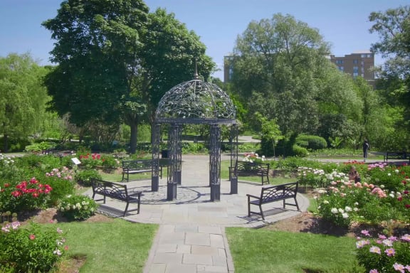 a garden with benches and a gazebo