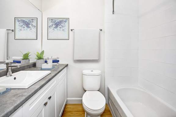 a white bathroom with a toilet and a tub and a sink