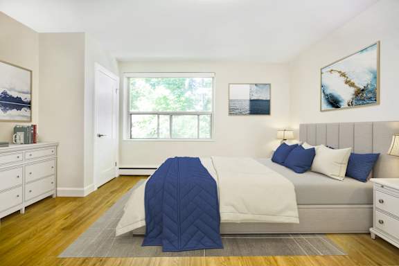 a bedroom with white walls and a bed with a blue blanket