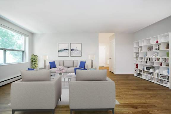 a living room with white furniture and a book shelf