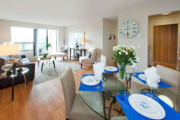 A dining room with a glass table set for four.