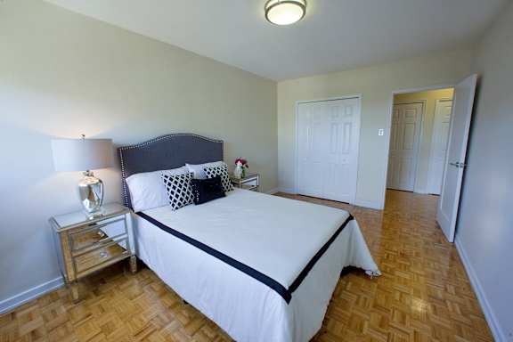 a bedroom with a white bed and a wooden floor