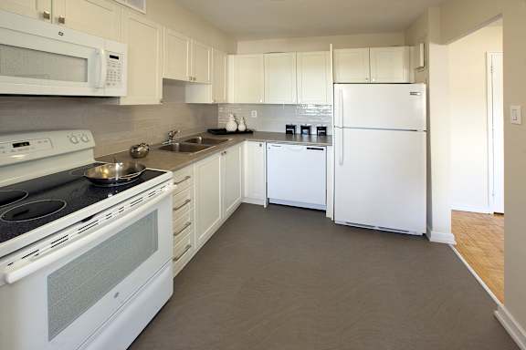 a kitchen with white appliances and white cabinets