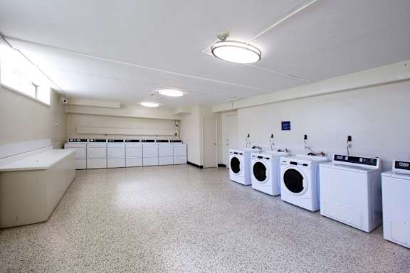a laundry room with a row of washes and dryers
