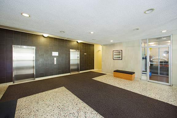 a lobby with a black and white carpet and glass doors