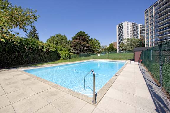 a swimming pool with a fence around it next to a building